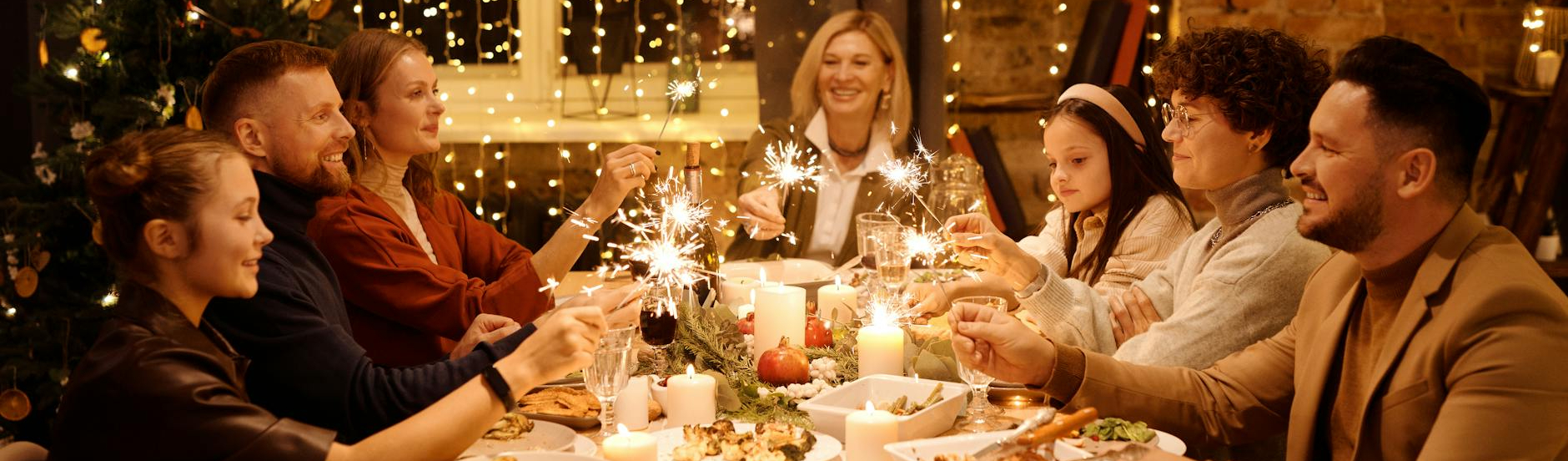 family celebrating christmas while holding burning sparklers